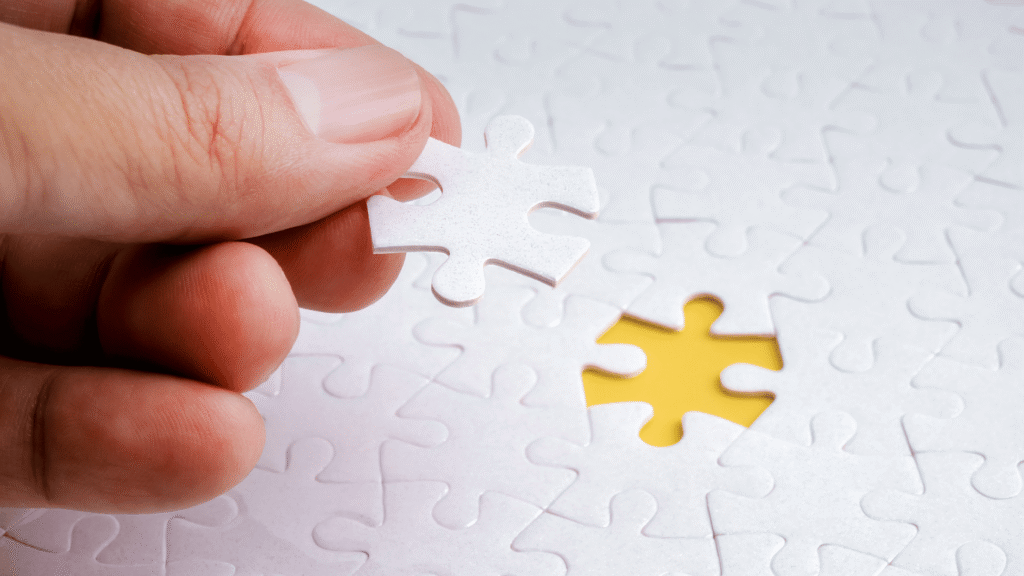 Hand placing the final piece of a white puzzle, symbolizing solving unexplained infertility or missing answers in fertility testing